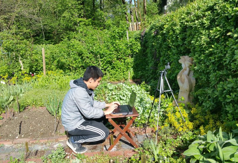 Mann mit Laptop und Messgerät im Garten